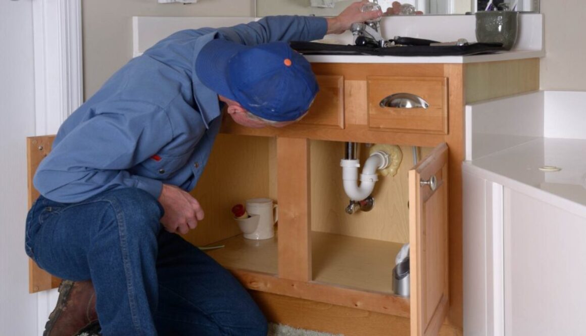 What is a Home Warranty, South Sound Inspections What is a Home Warranty, Blog Post, Image of a plumber fixing a leak in a bathroom sink